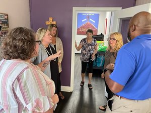 five females and one male stand in an entry hallway of the rock house kids facility