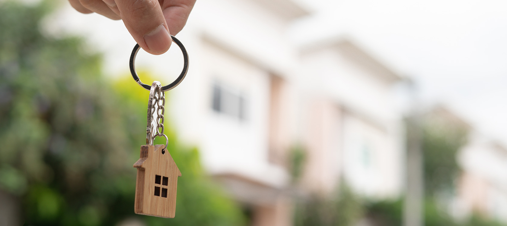 key chain with key and house in front of a blurred house